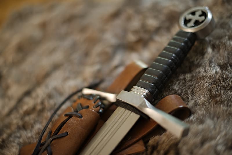 Dague de combat, pommeau croix tréflée et fourreau cuir brun lacé, porté oblique