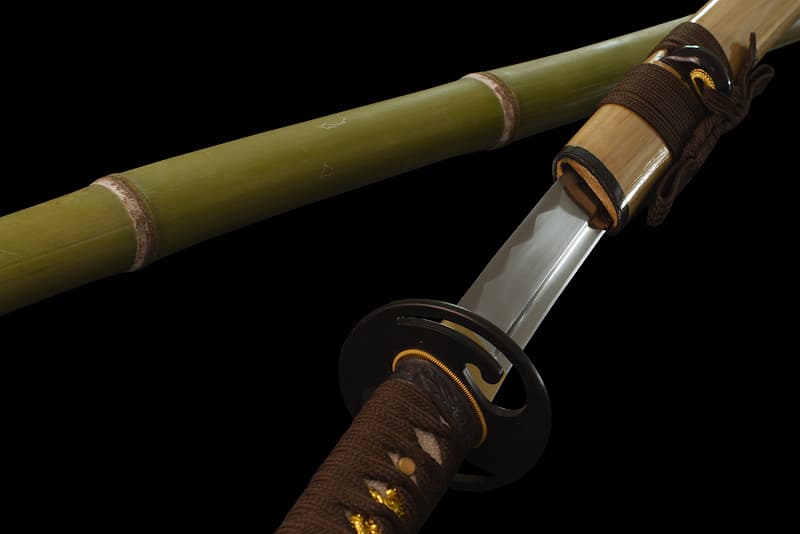 Katana tranchant avec fourreau (saya 鞘) en bois, livré dans un coffret en bois contenant un kit d'entretien, un support en bois laqué et une housse de protection en tissu | Je suis né dans une forge. L'Homme est venu me chercher au cœur de la terre pour me transformer, me magnifier, pour faire de moi la lame, souple, légère, vive que je suis aujourd’hui. J'ai accepté la morsure du feu, la puissance du marteau, la froideur de l'eau.