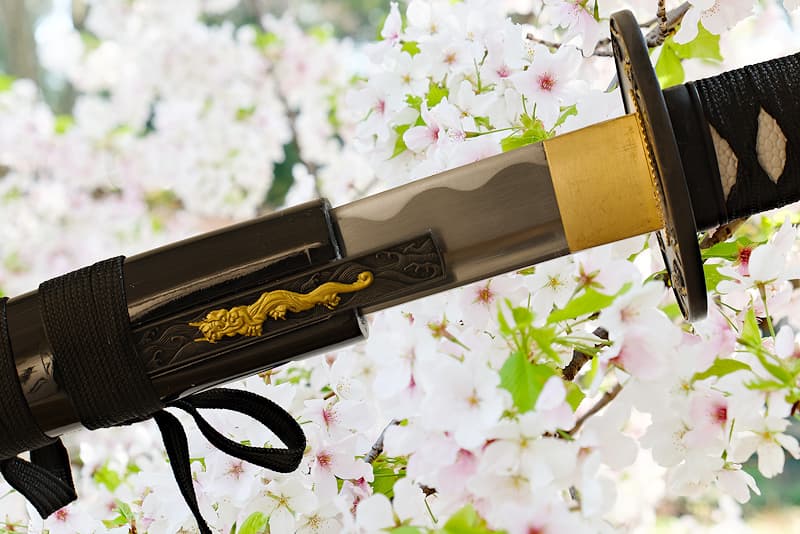 Katana tranchant avec fourreau (saya 鞘) en bois, livré avec une housse de protection en tissu | Comme dit le proverbe : « La plus belle des fleurs est celle de cerisier, le meilleur des hommes est le guerrier » (花は桜木人は武士).