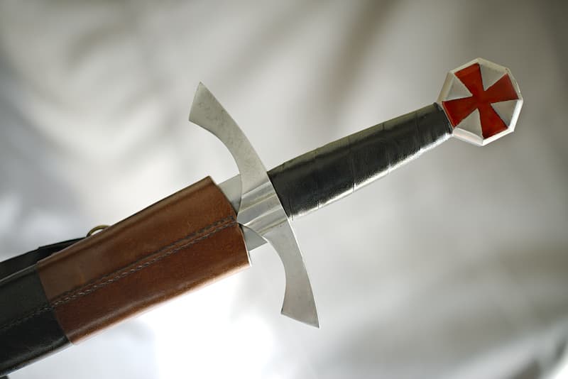 Épée médiévale de combat, pommeau octogonal avec croix pattée rouge, lame à gorge, fourreau en cuir brun et noir avec baudrier réglable