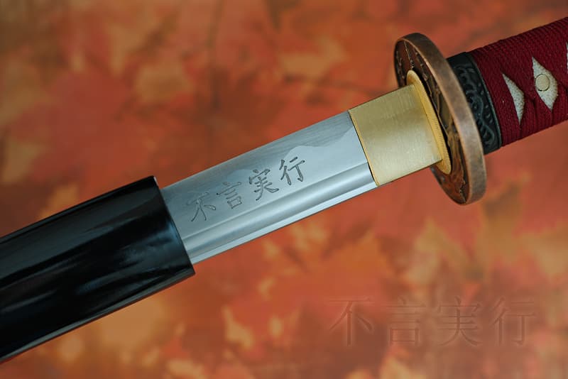 Katana affûté avec fourreau (Saya 鞘) noire, Tsuka-Ito (柄糸) et Sageo (下緒) rouge sombre, lame gravée (kanjis japonais), livré avec une housse de protection en tissu, dans un coffret en bois composite avec un support en bois verni avec protections et un kit d'entretien | Je n’ai servi qu’un seul maître samouraï. Forgée selon ses souhaits, je porte sa signature, sa citation favorite : « parler peu, mais agir ». Il est vrai qu’il a mis en pratique cette philosophie de l’efficacité. Vainqueur de tous les duels dans lesquels il fut engagé, il est resté fidèle jusqu’à ses derniers instants.