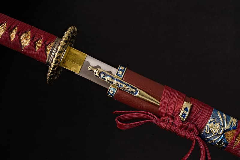 Katana de décoration avec deux Kozukas (小柄 couteau), décors marins et pirates, livré dans un coffret recouvert de tissu noir et rouge | Je suis née voici sept siècles, dans une forge particulière. Le forgeron qui m’a donné naissance travaillait dans une grotte dont le seul accès imposait d’escalader une falaise. En bord de mer, les falaises basaltiques de Tōjinbō (東尋坊 Sakai, préfecture de Fukui) constituent encore aujourd’hui une singularité géologique.