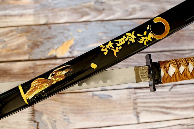 Katana de collection avec saya (鞘) noire sérigraphiée (samouraï et kanjis calligraphiés), tressages bruns | Mon maître fut surnommé le « Samouraï d’or », en référence à sa résilience et à sa capacité à transformer ses blessures en nouvelles passes d’armes. Il vécut entre les XIVᵉ et XVᵉ siècles, à la période durant laquelle le Japon donna naissance à cet art de réparer les objets cassés en soulignant ses cicatrices avec de la poudre d’or.