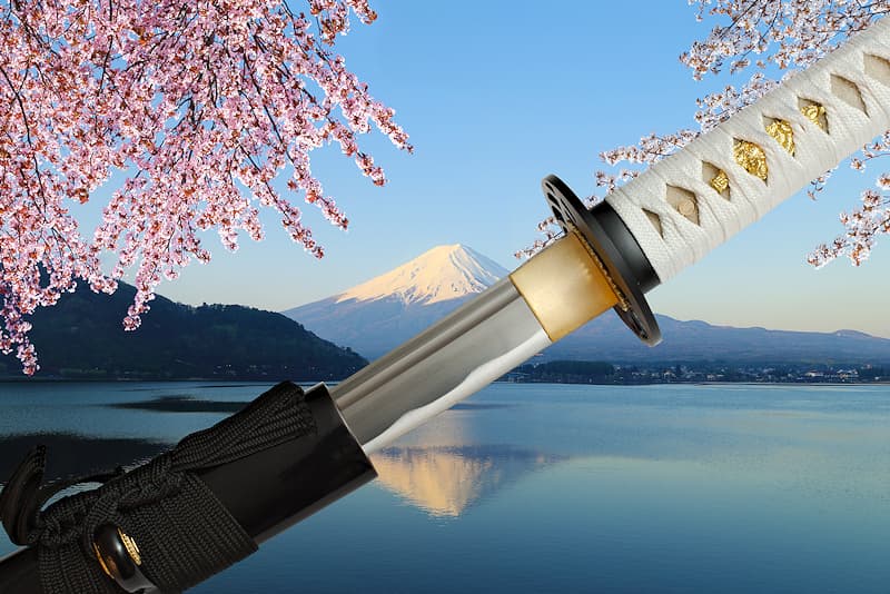 Wakizashi tranchant avec fourreau (saya 鞘) en bois laqué noir, sageo (下緒) noire, tsuka-Ito (柄糸) blanche, livré avec une housse de protection en tissu | Comme le katana que j’accompagne, je porte le nom de la force vitale liée à la floraison des arbres, symbole de la vie terrestre délicate et fragile, comme les fleurs de cerisiers. Connue également sous le nom de Sengen-sama, elle est le kami féminin (神, divinité ou un esprit shintoïste) du Mont Fuji (富士山 Fujisan), la plus haute montagne du Japon.