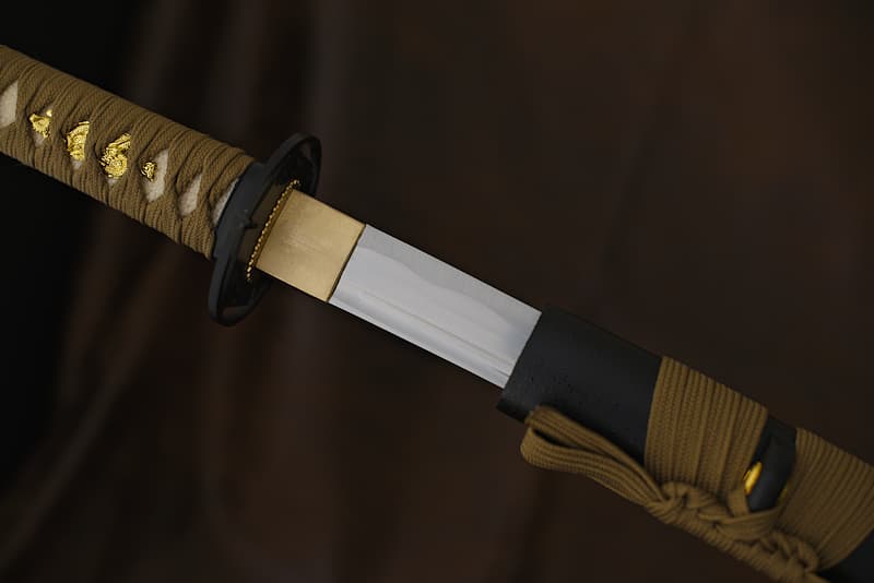 Wakizashi tranchant avec fourreau (saya 鞘) en bois laqué noir avec reliefs (gouttelettes), tressages (tsuka-Ito 柄糸 et sageo 下緒) marron (brun) | La légende raconte que je suis née à partir d’un morceau de terre extrait de la Montagne sacrée, Fujisan (富士山). Le maître forgeron qui m’a donné vie aurait choisi le meilleur minerai pour le transformer, après des semaines de dur labeur en fine lame. Polie, affûtée comme un rasoir, j’ai ensuite été confiée à un samouraï qui participa à la Bataille de Sekigahara (関ヶ原の戦い), en 1600.