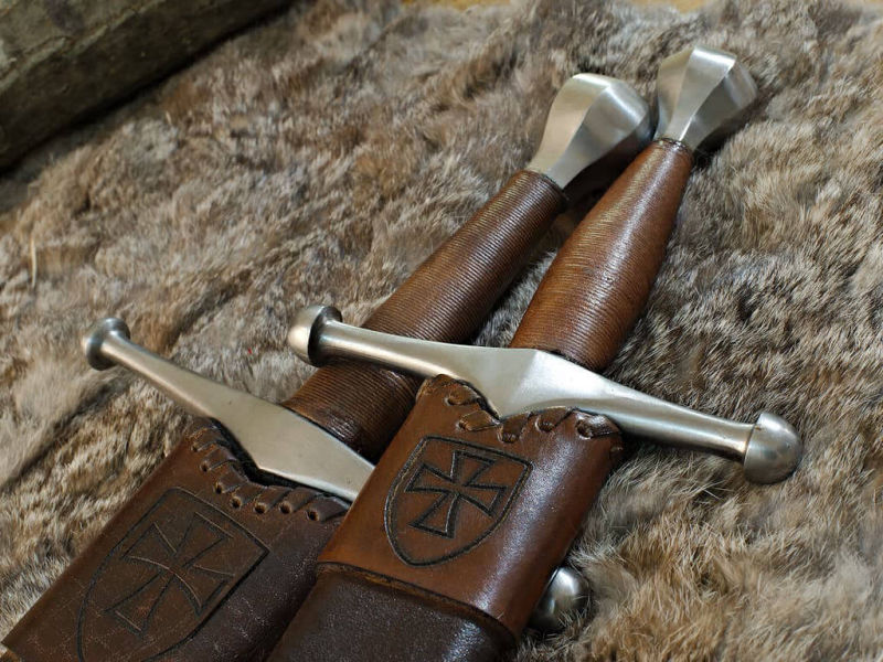 Épée et dague médiévale allemande, posées sur une peau naturelle