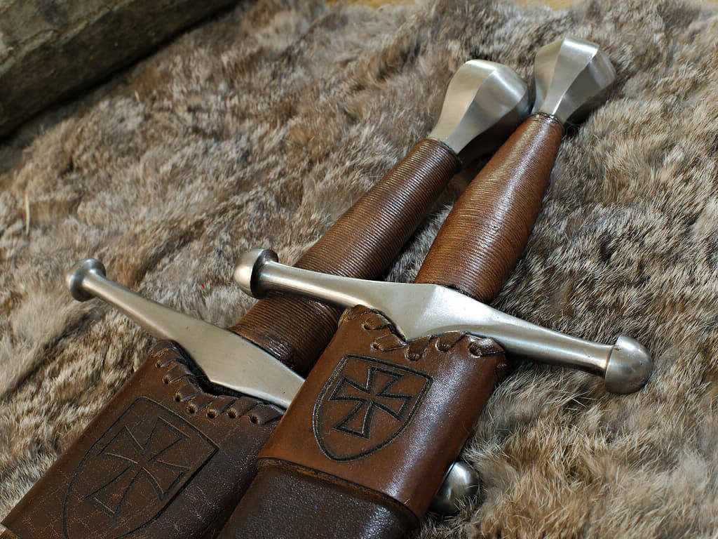 Épée et dague médiévale allemande, posées sur une peau naturelle
