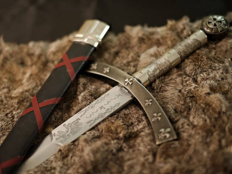 Mise en scène de l'épée de la Septième Croisade, avec des décoration symboliques liées au roi de France Saint-Louis (croix et Fleur de Lys)