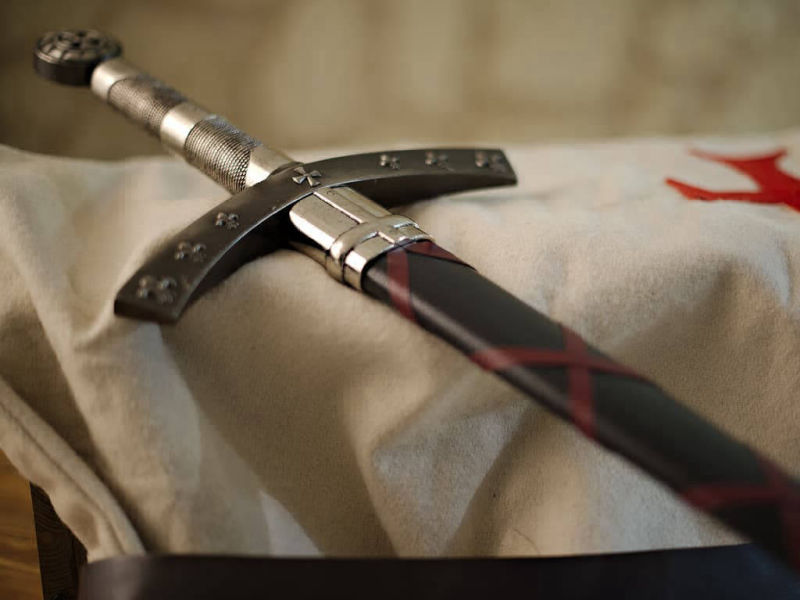 L'épée de la Septième Croisade posée sur un tabard blanc de chevalier croisé