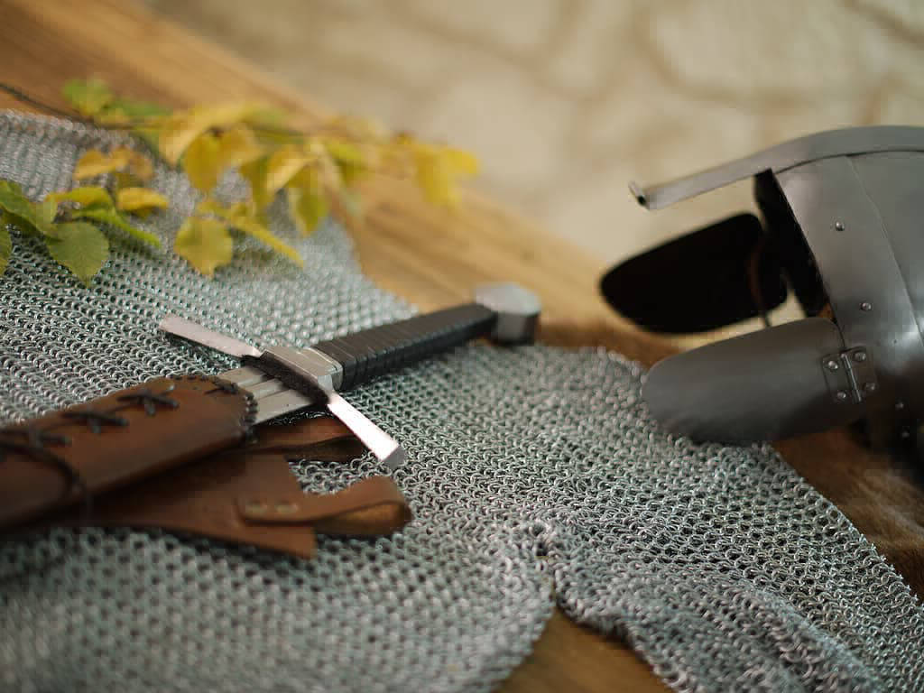 Mise en scène d'une cotte de mailles médiévale avec un casque et une épée de combat Mise en scène d'une cotte de mailles médiévale avec un casque et une épée de combat