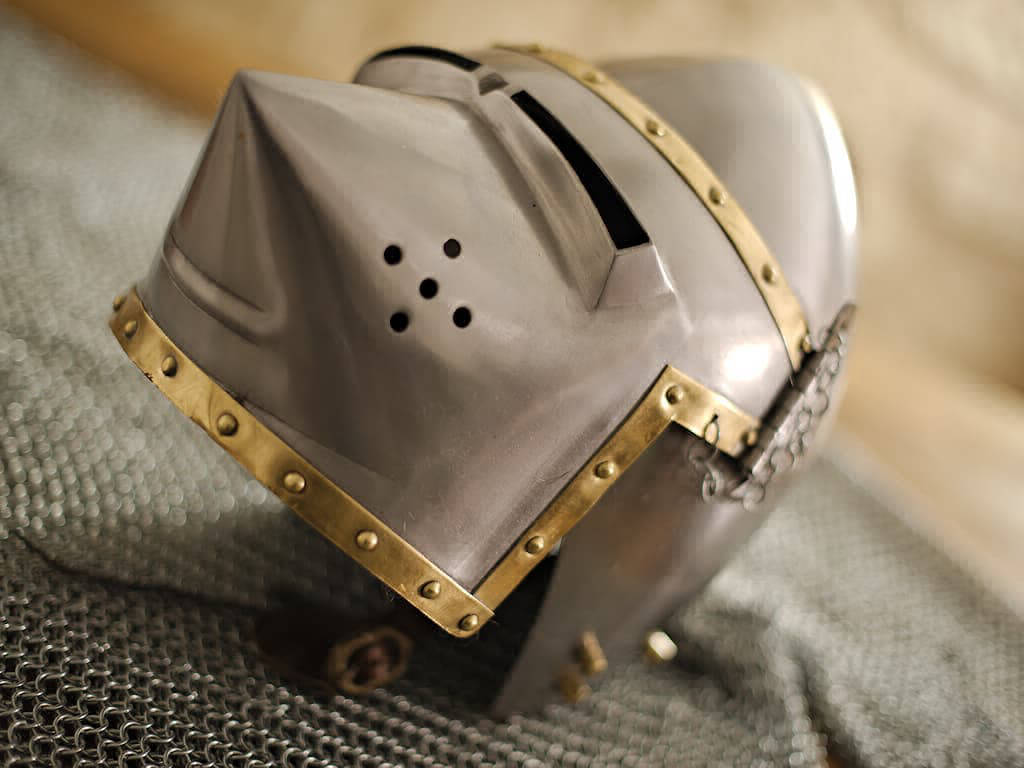 Casque Pigface bassinet ouvert, posé sur une cotte de mailles médiévale