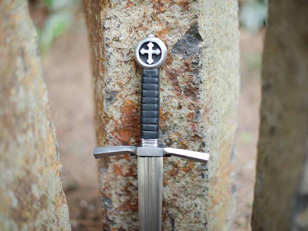 Dague médiévale du chevalier croisé posée sur des pierres naturelles verticales