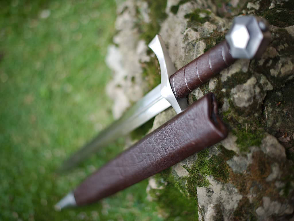 Dague médiévale de combat « Lightbane » posée sur un rocher recouvert de mouse naturelle Dague médiévale de combat « Lightbane » posée sur un rocher recouvert de mouse naturelle