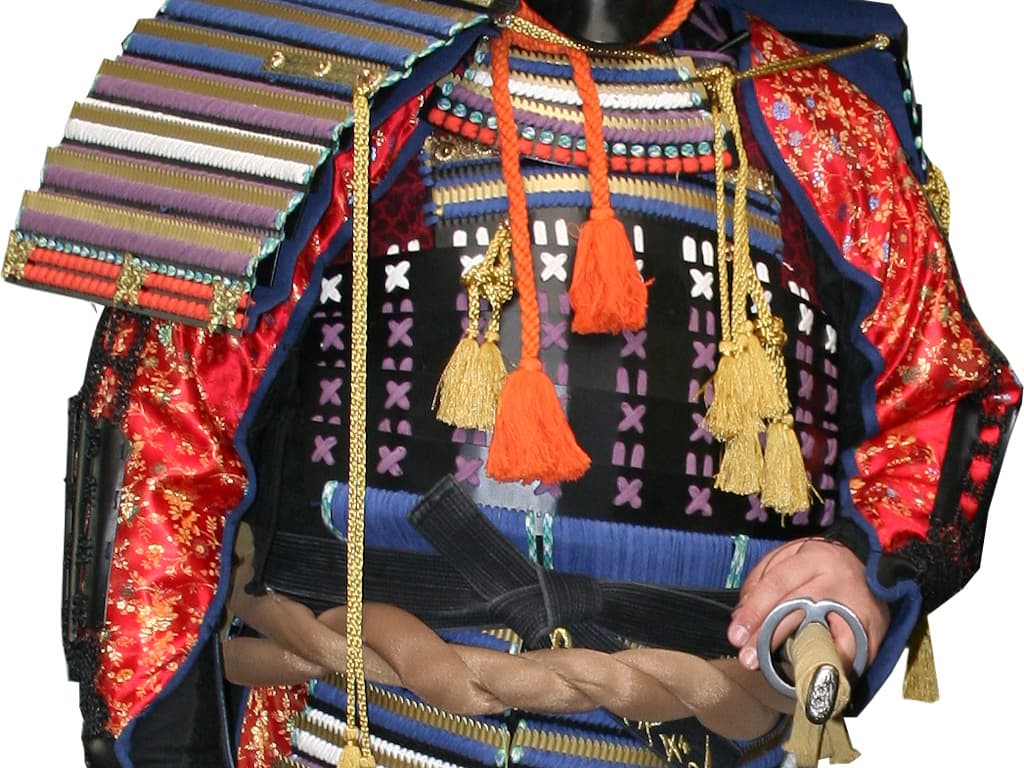 L'amure de samouraï rouge portée par un pratiquant d'arts martiaux, avec un katana