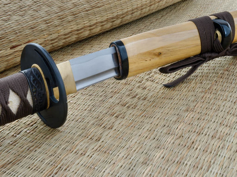 Katana aiguisé bois (mù, 木) métal (jīn, 金), posé sur une natte de paille Katana aiguisé bois (mù, 木) métal (jīn, 金), posé sur une natte de paille