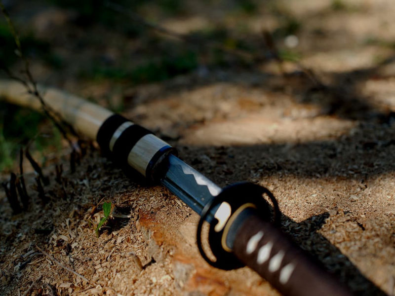 Katana aiguisé bois (mù, 木) métal (jīn, 金), sur le sol couvert de coupeaux de bois Katana aiguisé bois (mù, 木) métal (jīn, 金), sur le sol couvert de coupeaux de bois