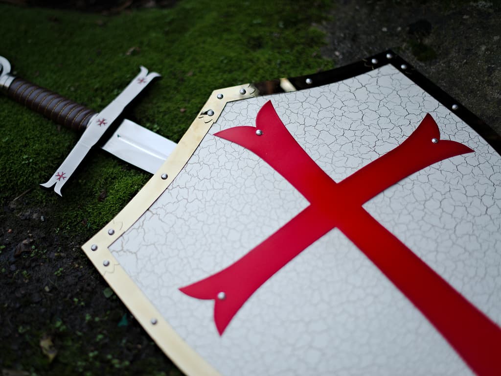 Bouclier templier avec épée sur ambiance de rocher et de mousse naturelle Bouclier templier avec épée sur ambiance de rocher et de mousse naturelle