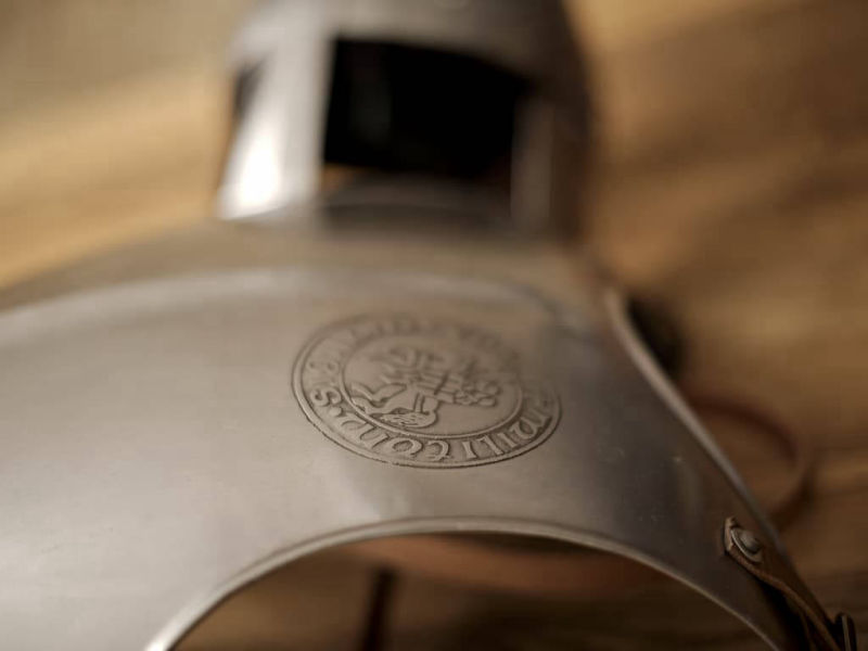 Plastron templier sur une table médiévale avec un casque de chevalier Plastron templier sur une table médiévale avec un casque de chevalier